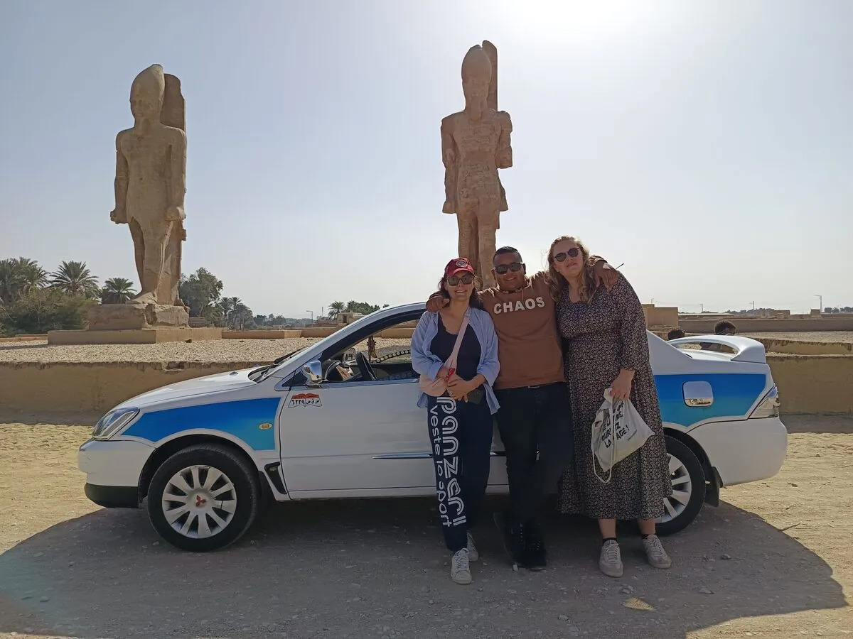 Travelers with the taxi by the statues